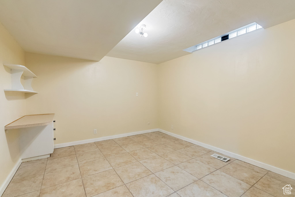 Interior space with light tile patterned floors, baseboards, and visible vents