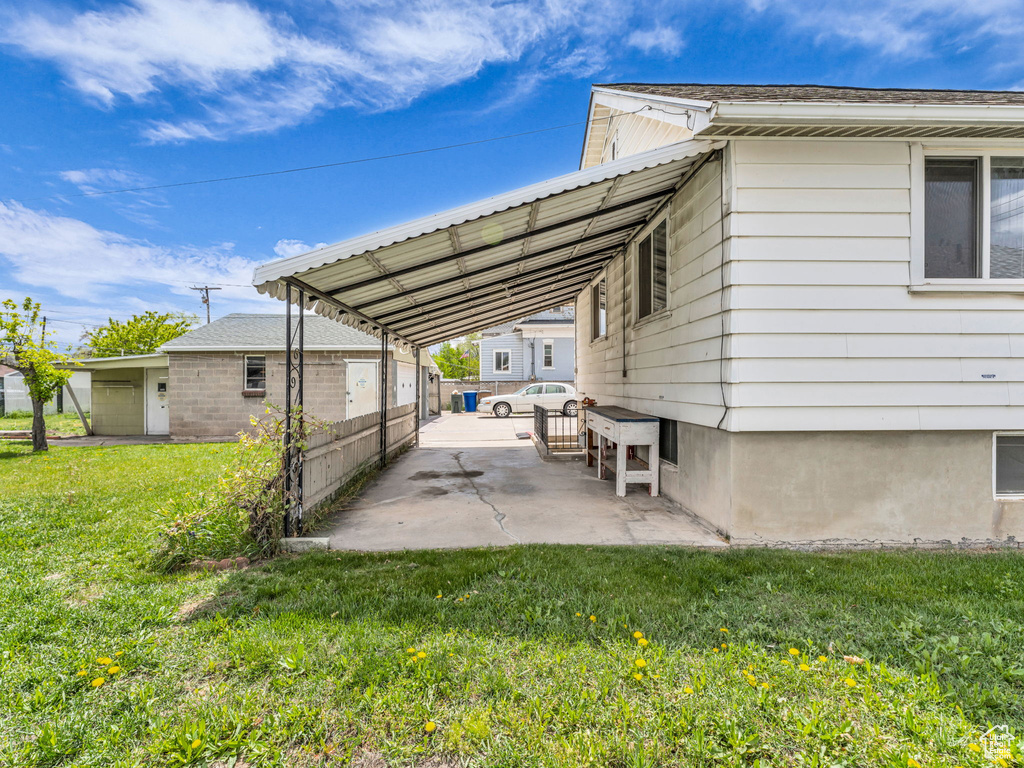 View of parking featuring fence and an attached carport