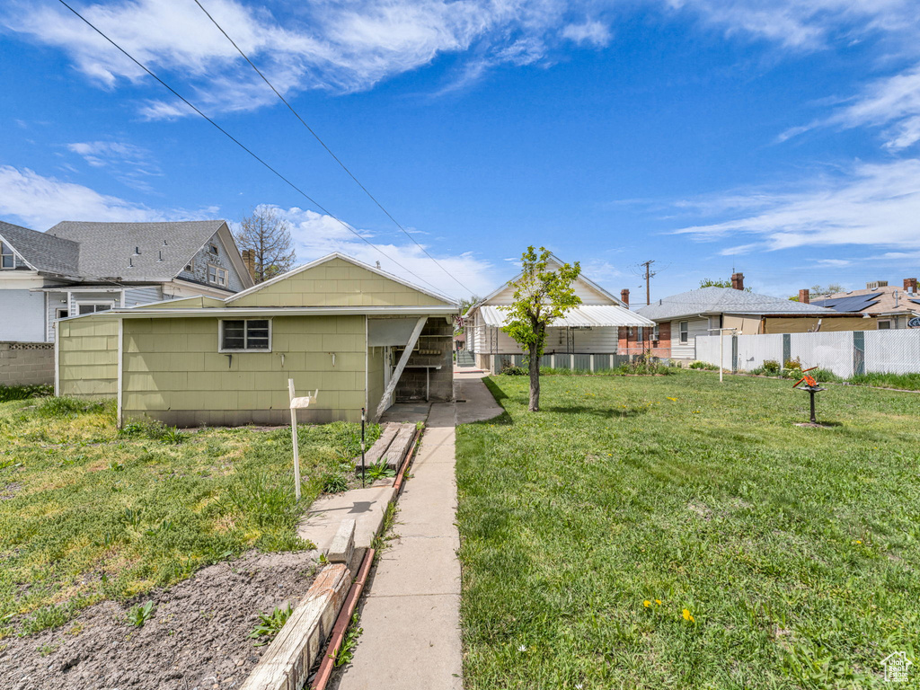Rear view of property with fence and a yard