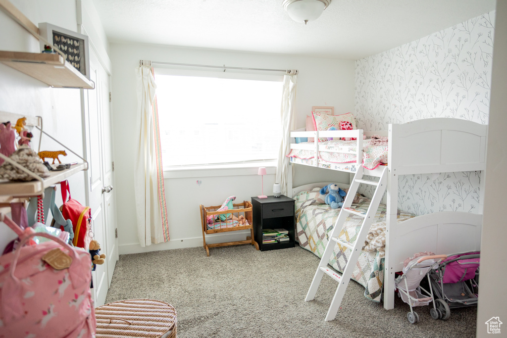 Bedroom with wallpapered walls and carpet