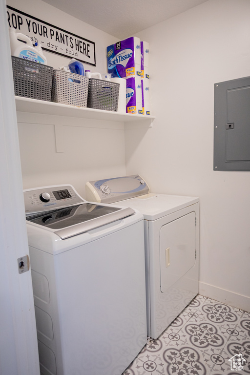 Laundry area with laundry area, baseboards, independent washer and dryer, and electric panel
