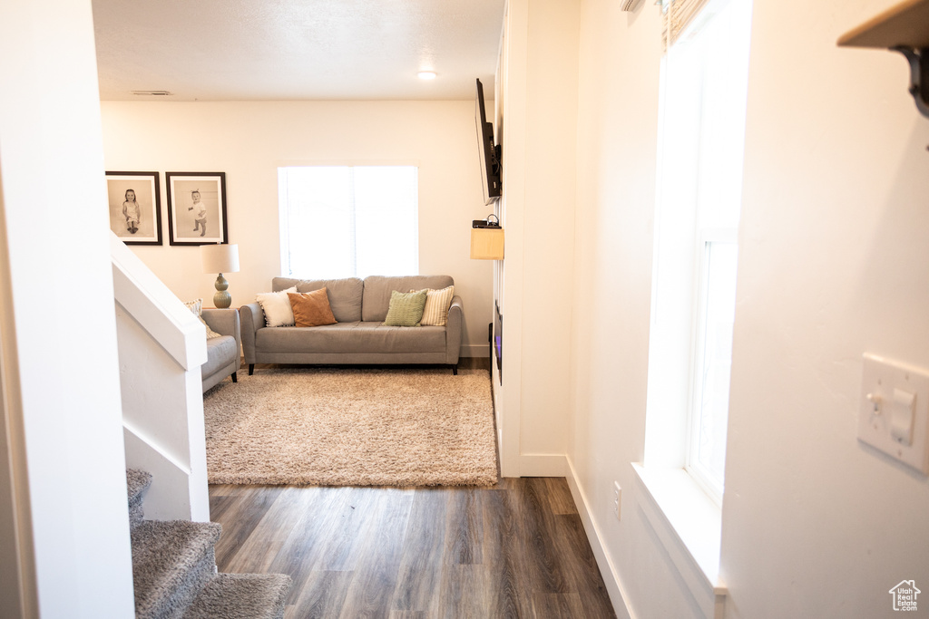Living area featuring stairway, baseboards, and dark wood-type flooring