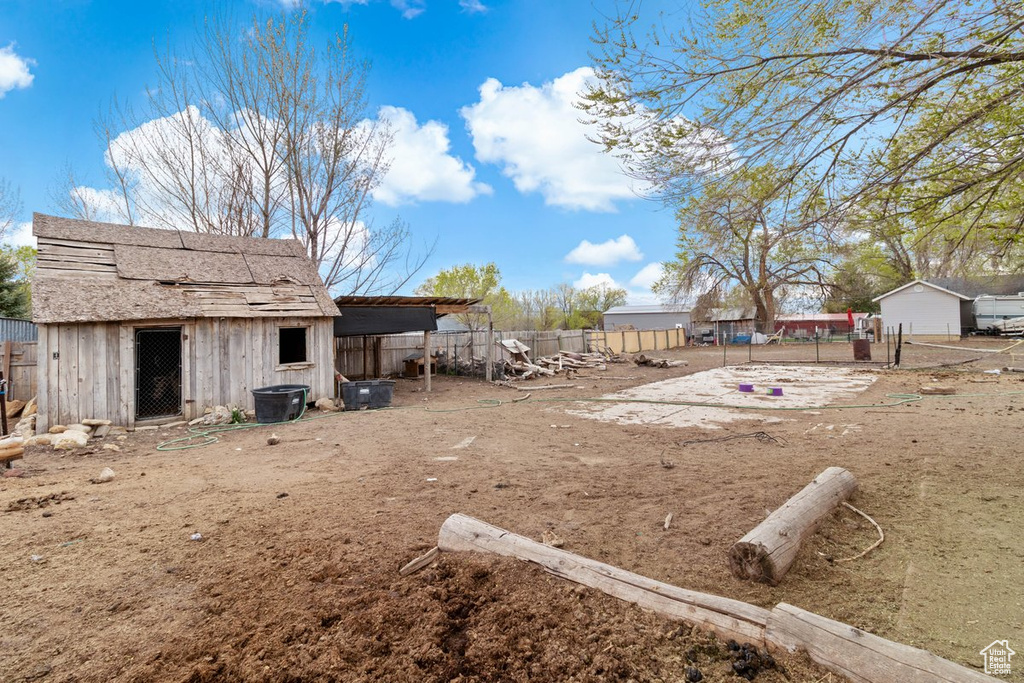 View of yard featuring an outdoor structure and fence