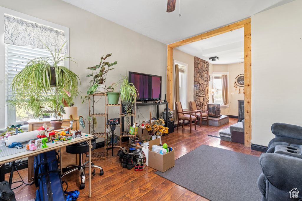 Living room featuring wood-type flooring, a ceiling fan, and a desk
