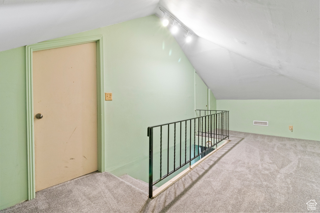 Bonus room featuring lofted ceiling and carpet floors