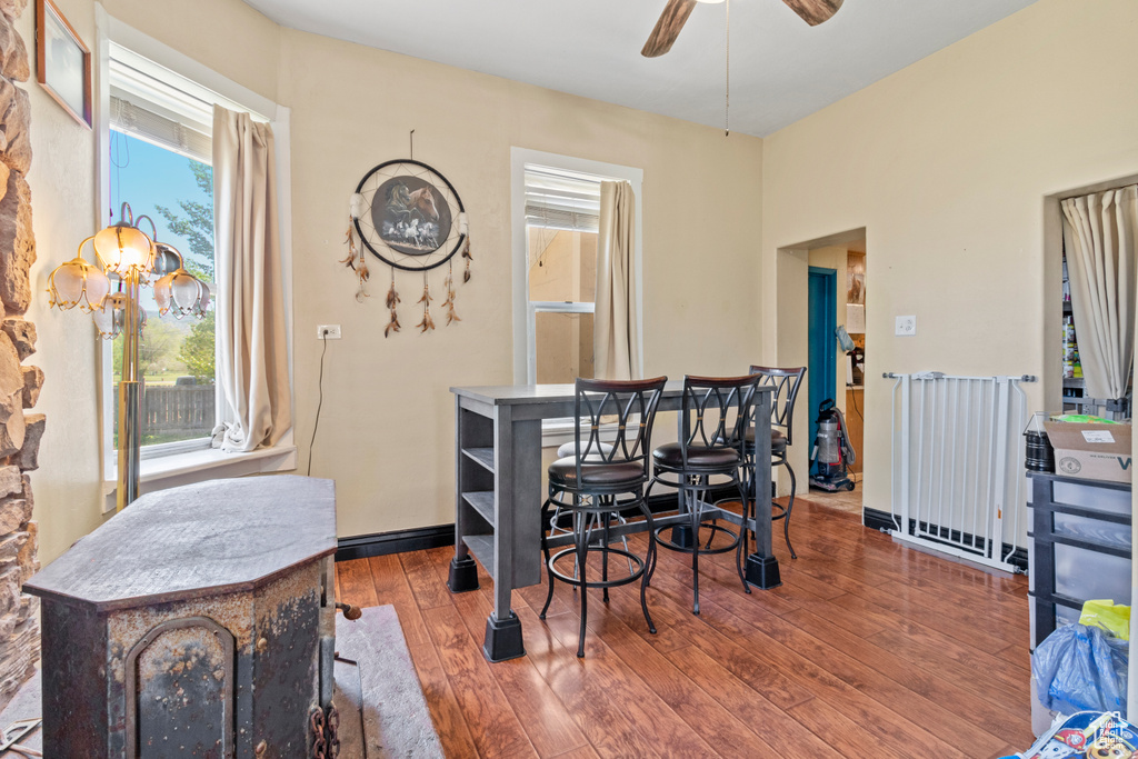 Dining room featuring hardwood / wood-style flooring, a ceiling fan, a chandelier, and baseboards