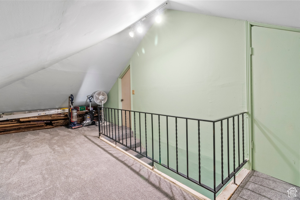 Additional living space with lofted ceiling and carpet