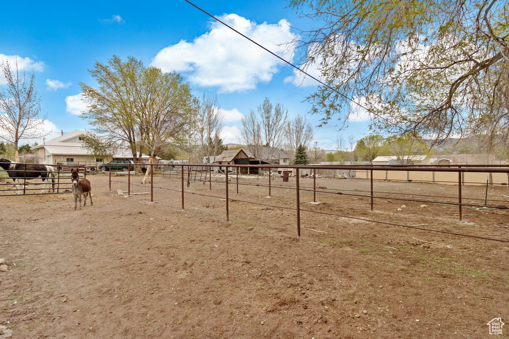 View of yard with fence and a rural view