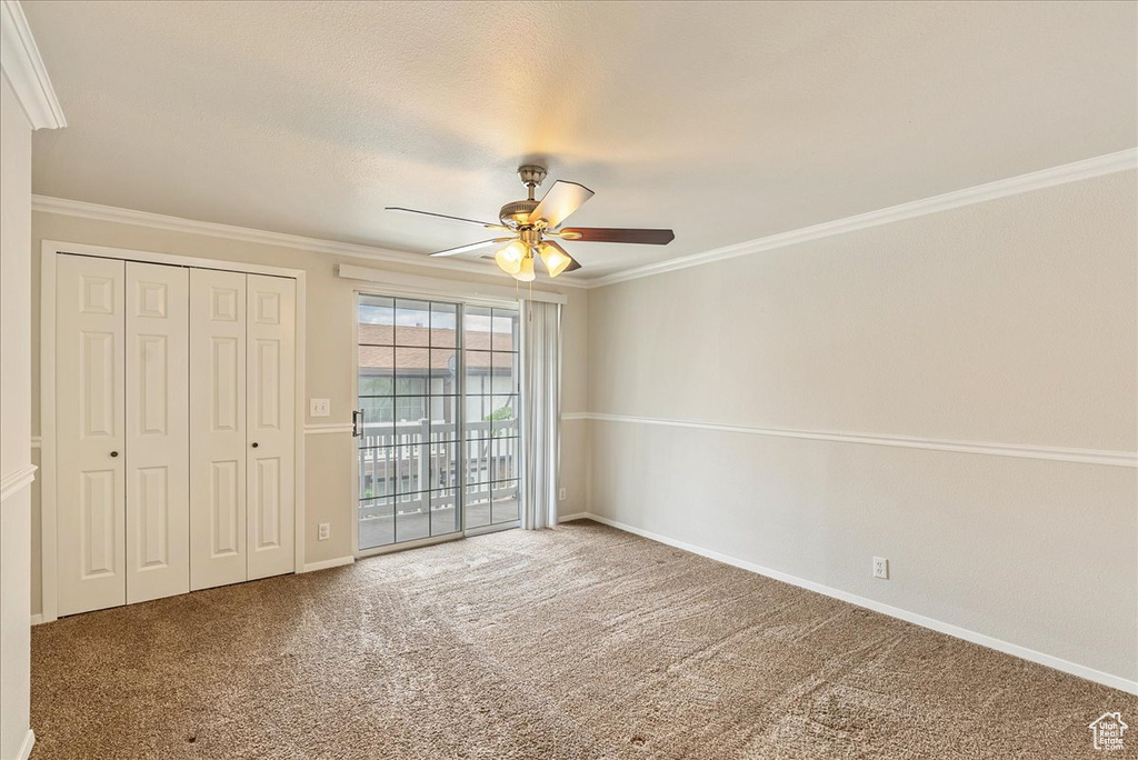 Unfurnished bedroom with crown molding, carpet floors, baseboards, access to outside, and a ceiling fan