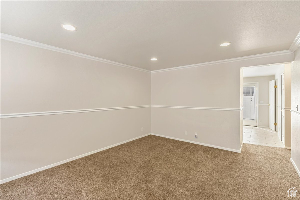 Carpeted empty room featuring crown molding, recessed lighting, and baseboards