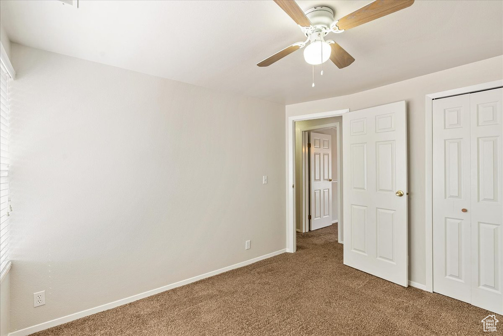 Unfurnished bedroom featuring baseboards, carpet, ceiling fan, and a closet
