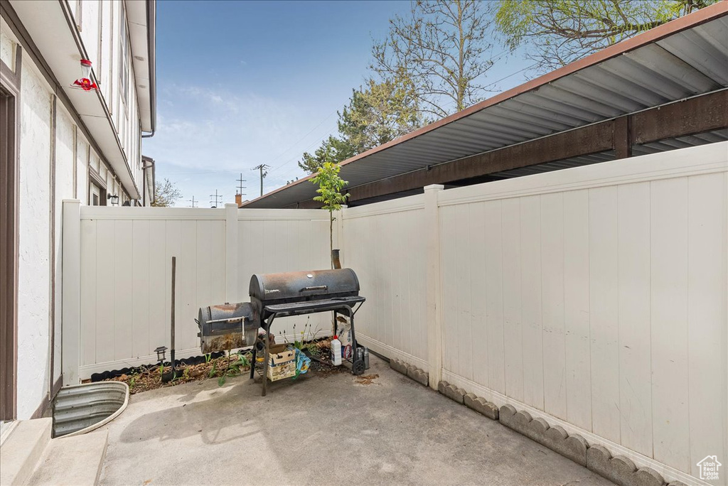 View of patio with fence and grilling area