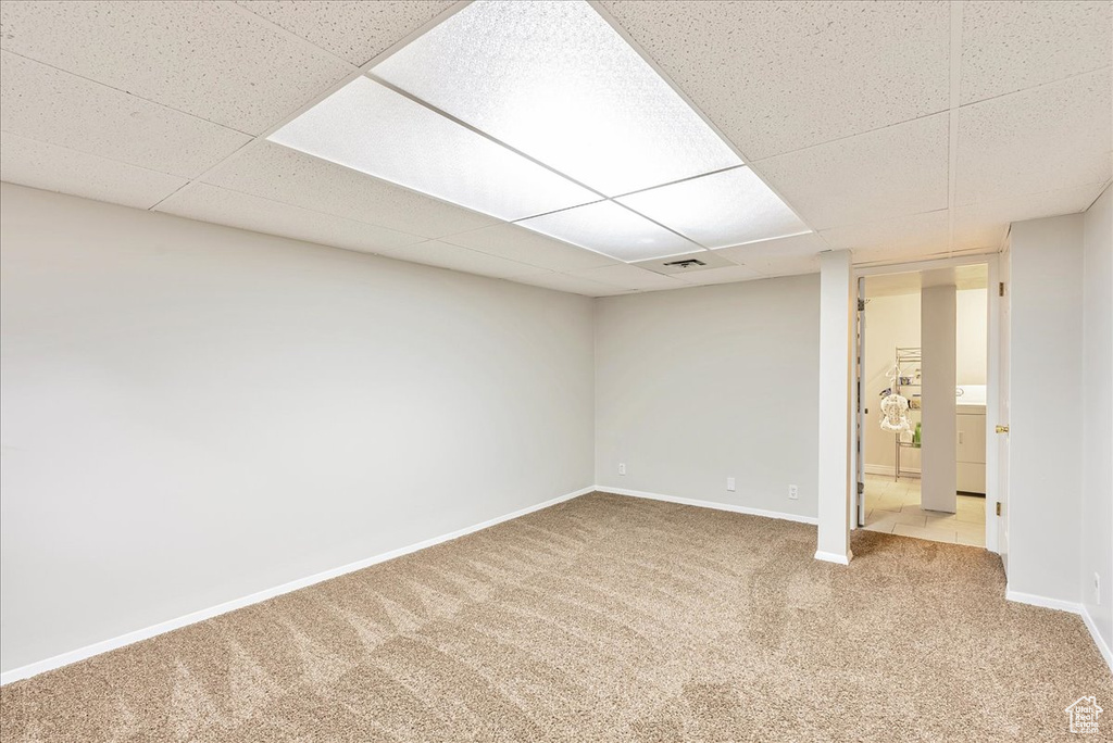 Finished basement featuring carpet floors, baseboards, a drop ceiling, and visible vents