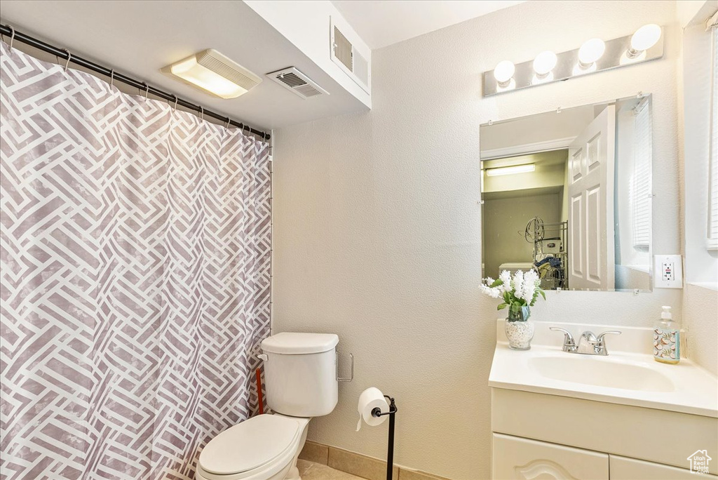 Bathroom featuring toilet, visible vents, a shower with shower curtain, and vanity