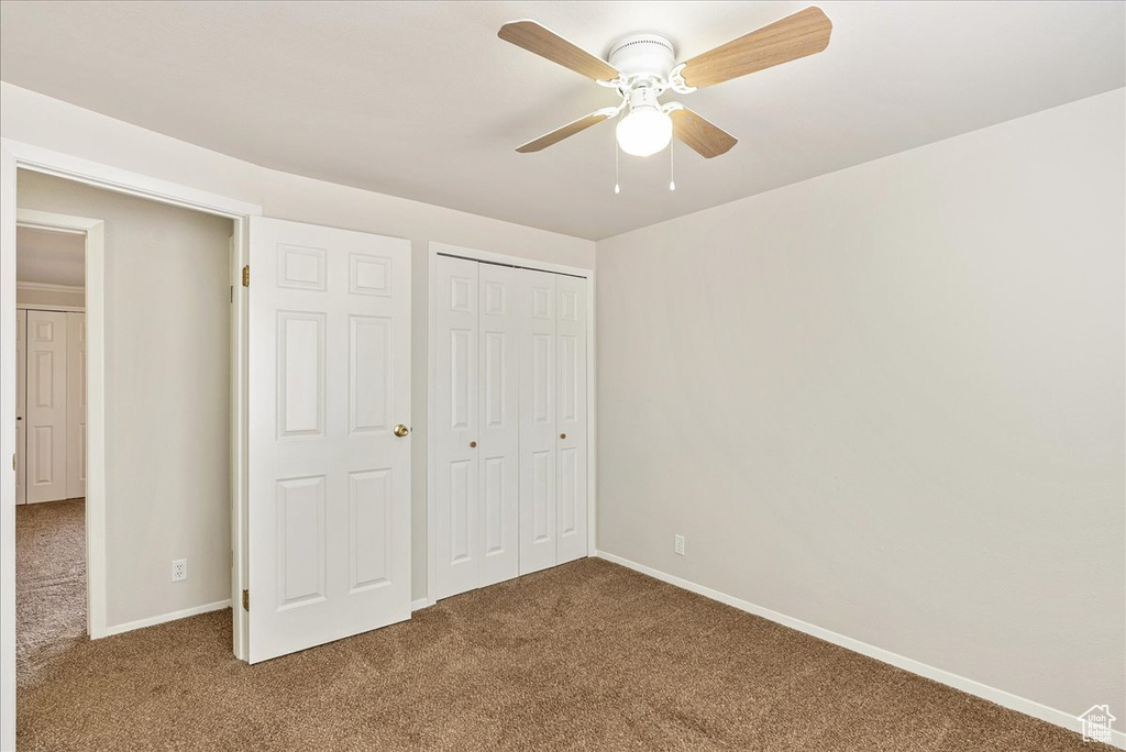 Unfurnished bedroom featuring baseboards, carpet flooring, and a closet