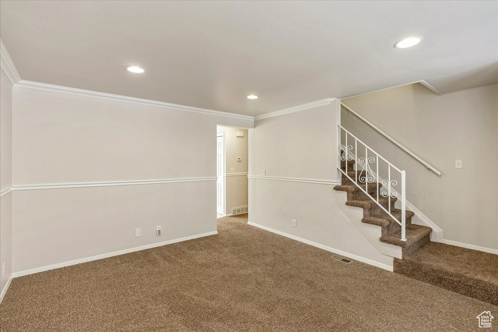 Interior space with carpet floors, ornamental molding, and recessed lighting