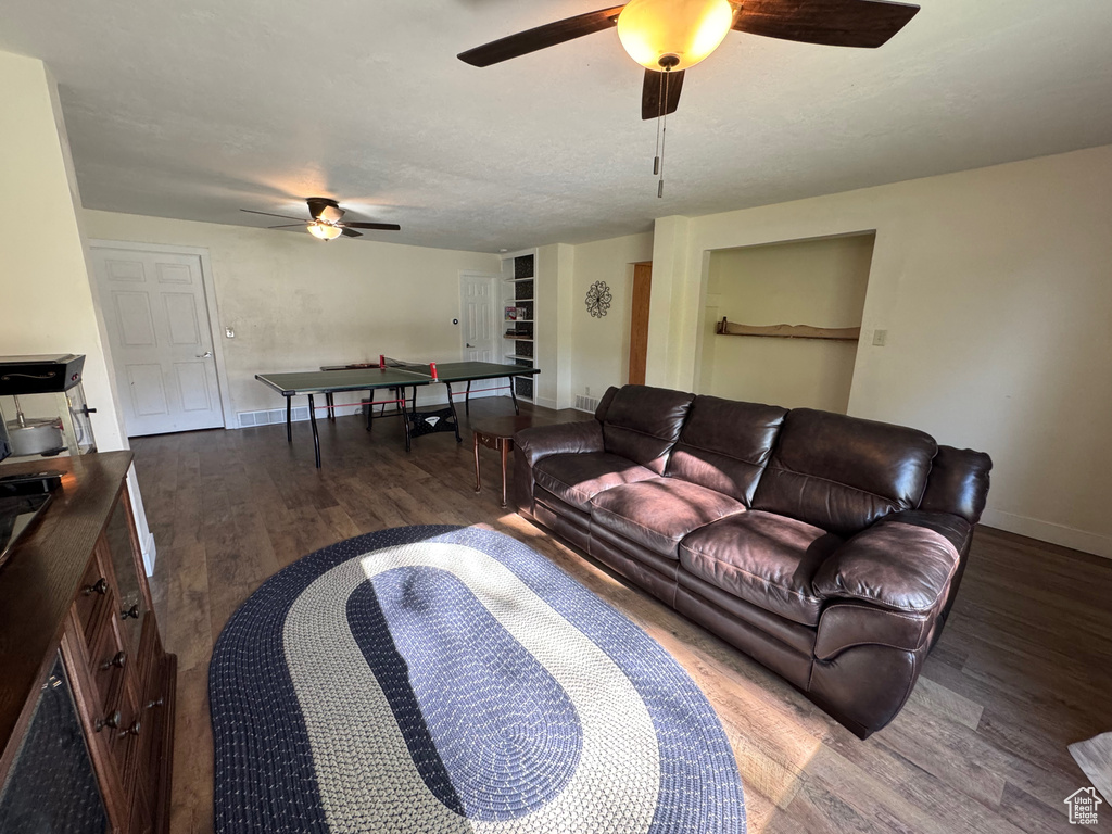 Living area with baseboards, ceiling fan, and wood finished floors