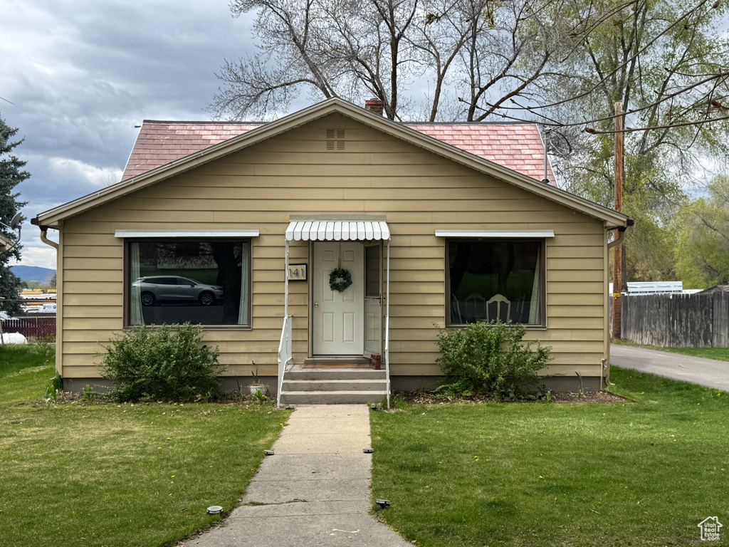 Bungalow with fence and a front yard