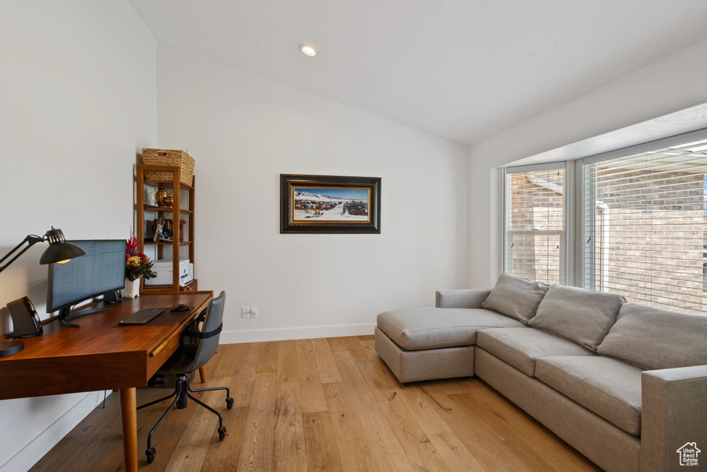 Office space with lofted ceiling, light wood finished floors, baseboards, and recessed lighting