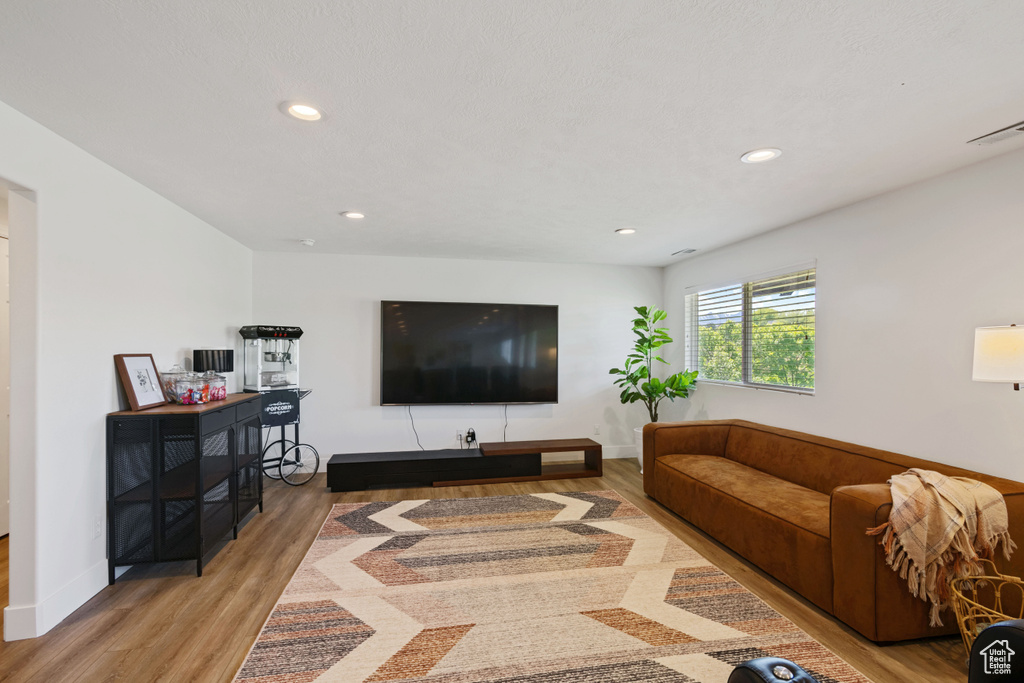 Living area with light wood finished floors, recessed lighting, and baseboards