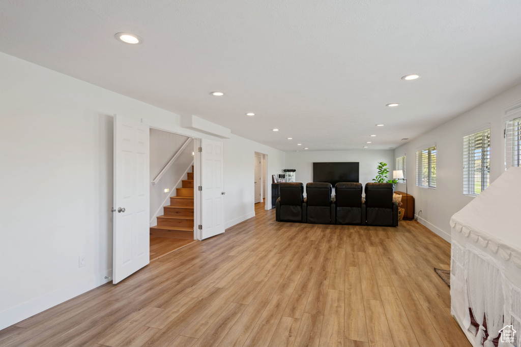 Living area featuring recessed lighting, light wood-style flooring, stairway, and baseboards