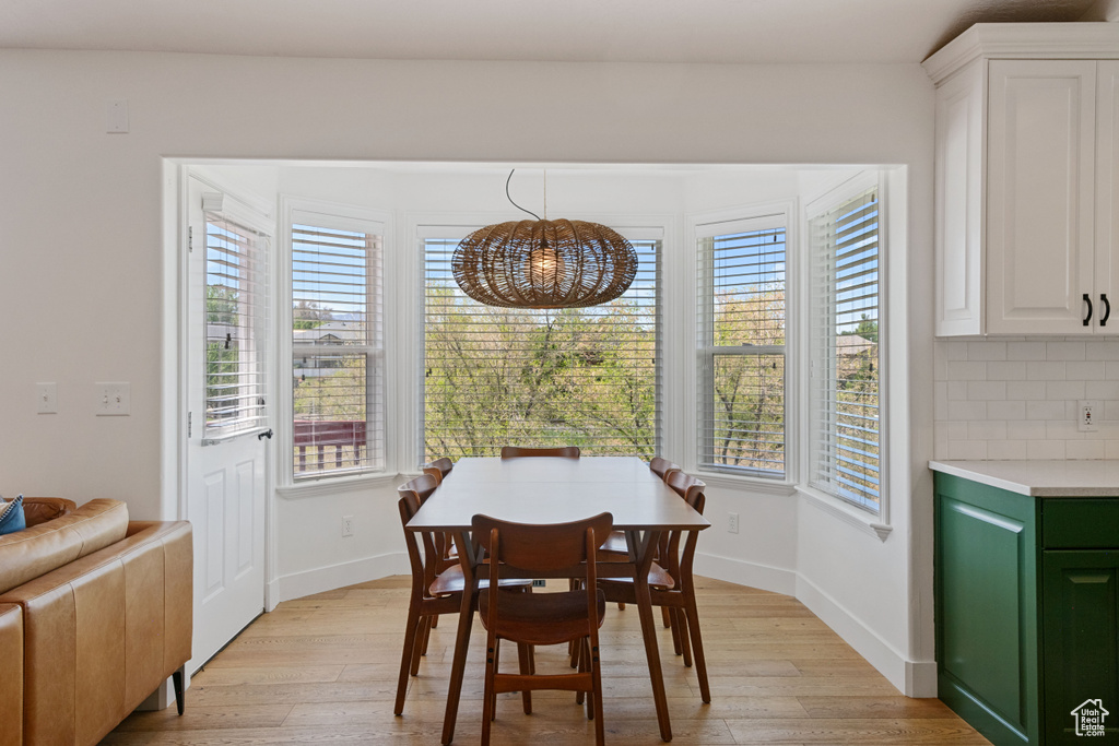 Dining area with a chandelier, light wood-style floors, and plenty of natural light