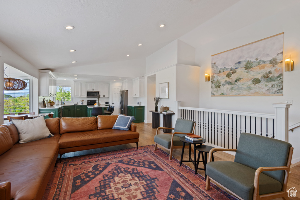 Living area featuring lofted ceiling, light wood-style flooring, and recessed lighting