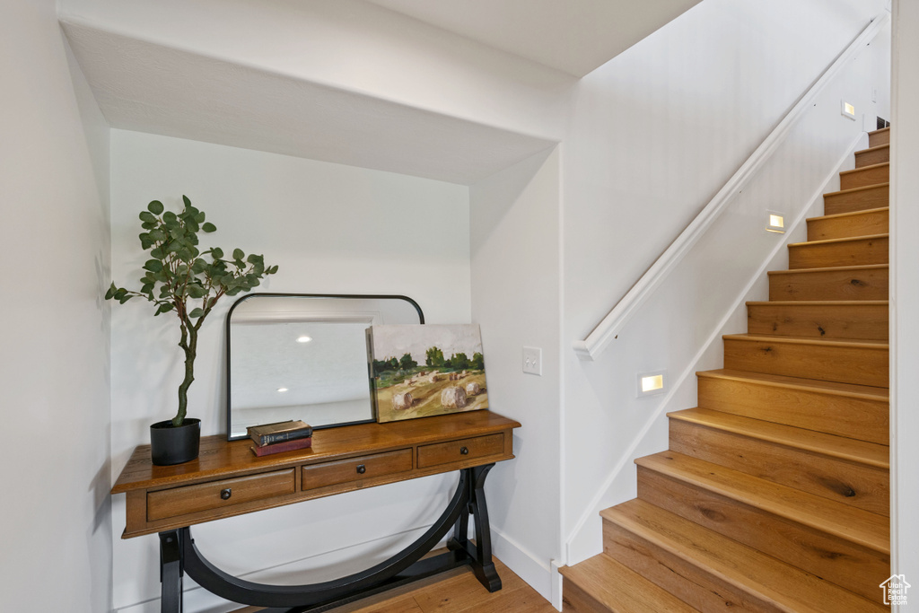Entryway with wood finished floors, stairway, and baseboards