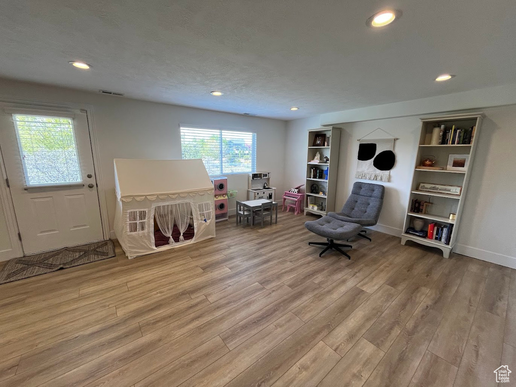 Sitting room with recessed lighting, baseboards, visible vents, and light wood-style floors