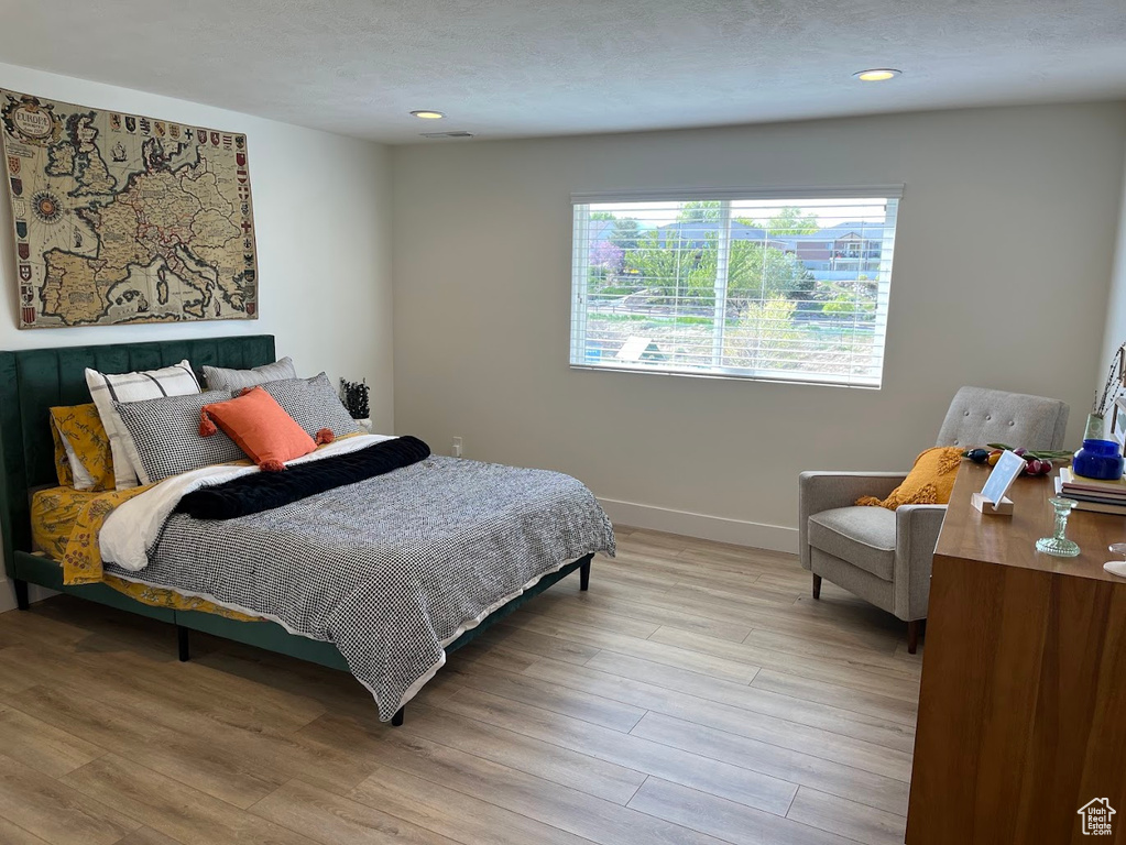 Bedroom with baseboards, recessed lighting, and light wood-style flooring