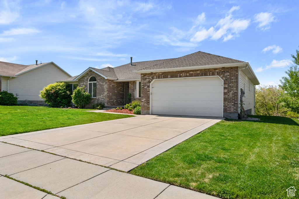 Single story home with brick siding, concrete driveway, a front lawn, an attached garage, and roof with shingles