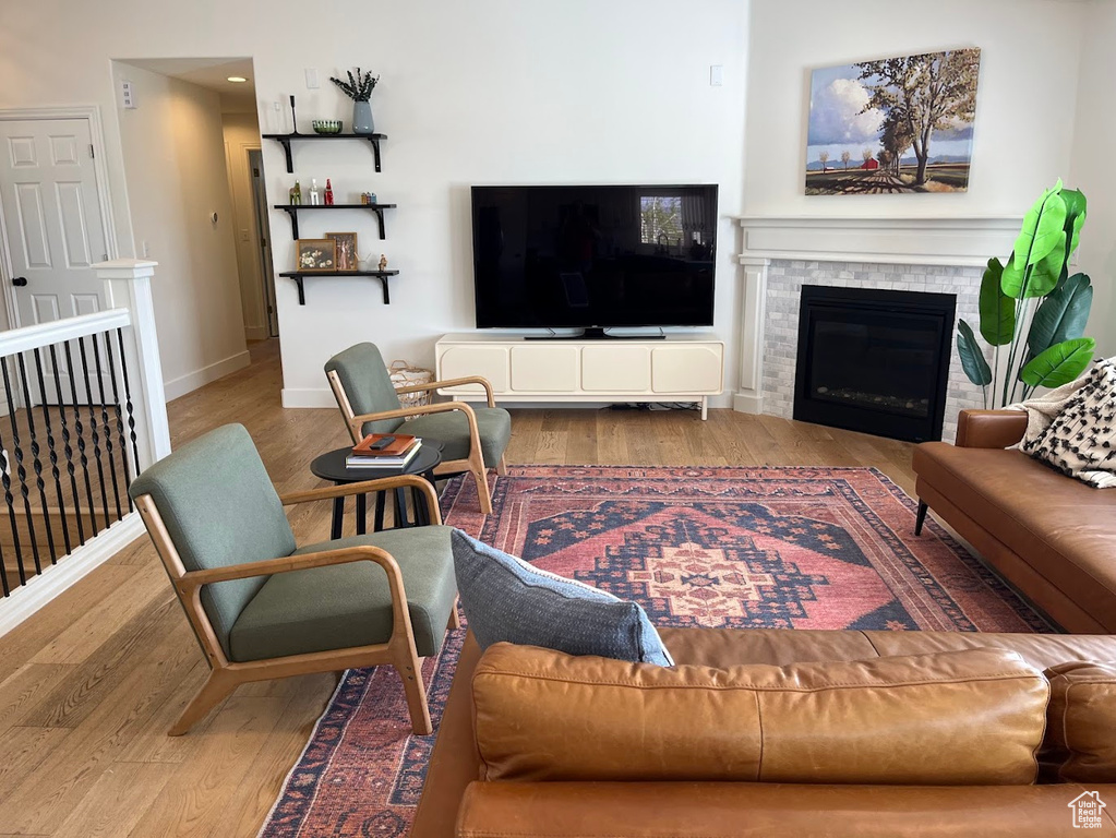 Living room featuring baseboards, a glass covered fireplace, and wood finished floors
