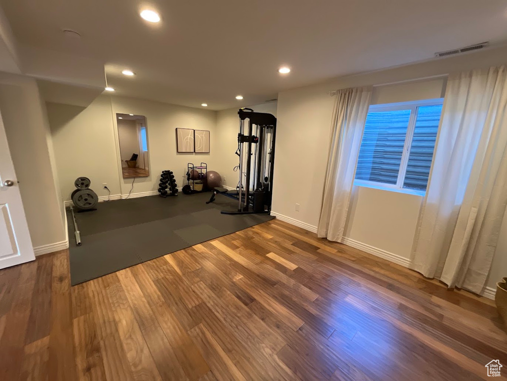 Exercise room with recessed lighting, baseboards, visible vents, and wood finished floors