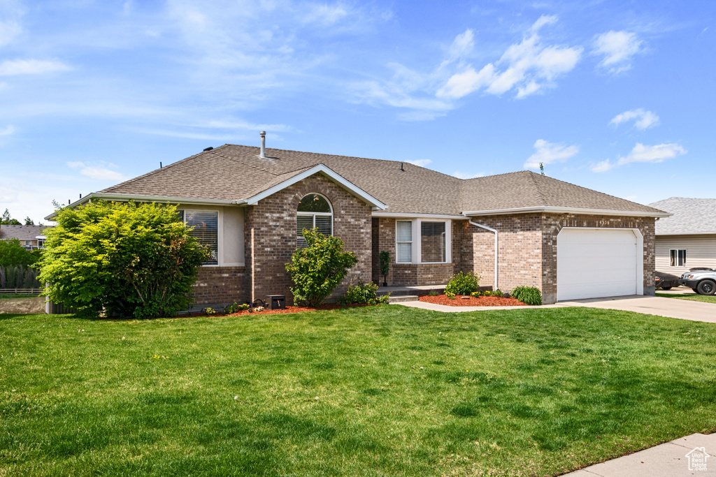 Ranch-style home featuring roof with shingles, brick siding, an attached garage, concrete driveway, and a front yard