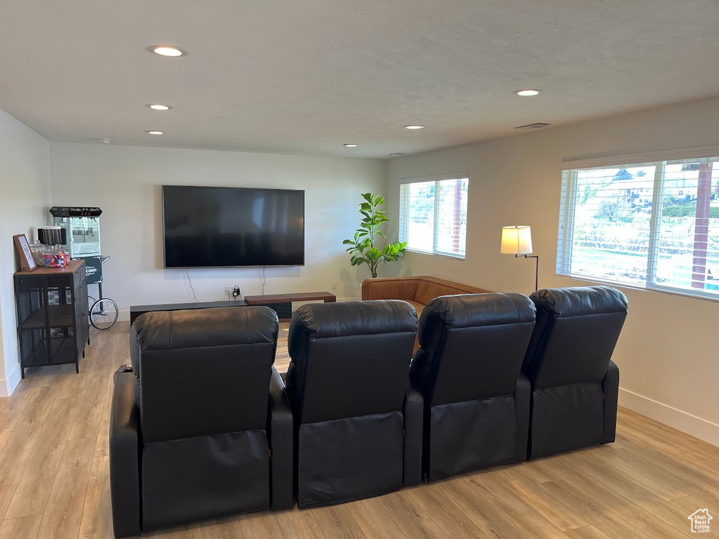 Home theater with recessed lighting, baseboards, and light wood finished floors