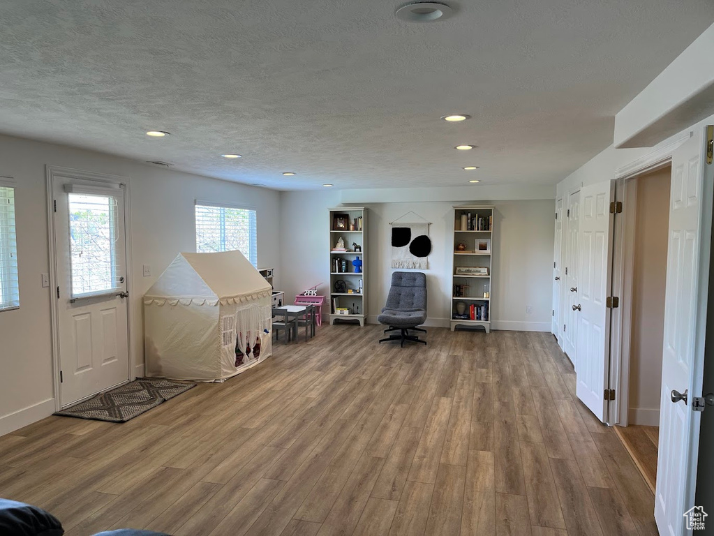 Game room with recessed lighting, baseboards, wood finished floors, and a textured ceiling