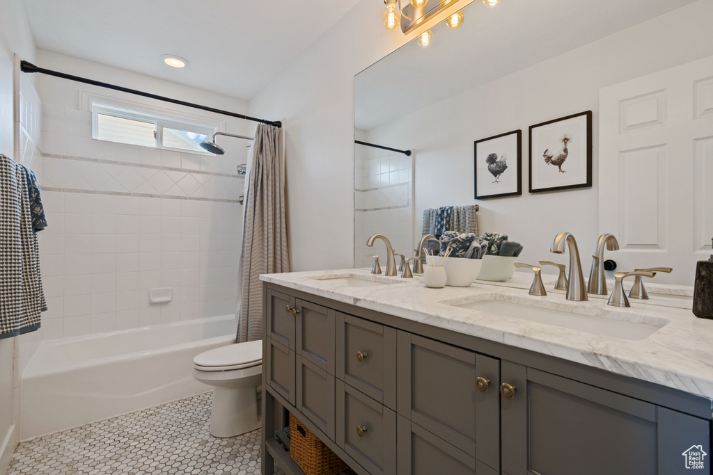 Full bathroom featuring shower / tub combo, double vanity, toilet, and tile patterned flooring