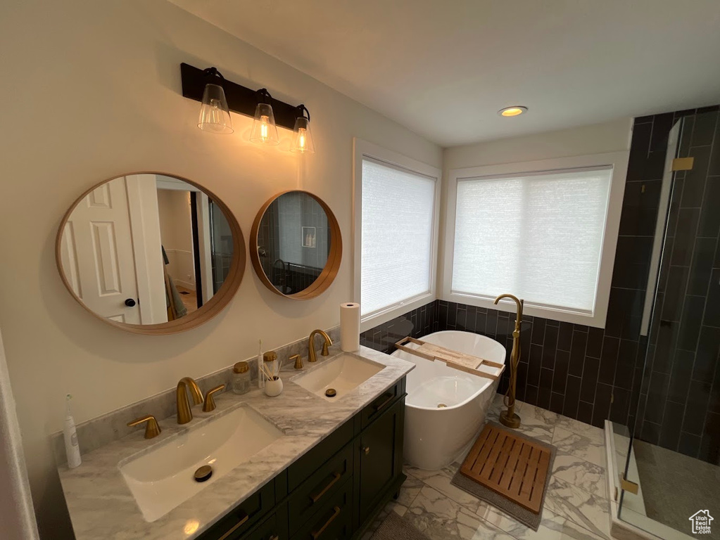 Bathroom with a soaking tub, a sink, marble finish floor, and a stall shower