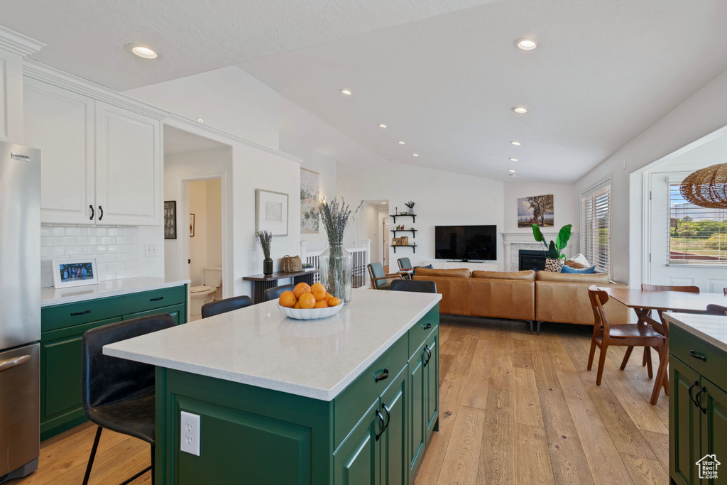 Kitchen featuring green cabinets, a fireplace, freestanding refrigerator, white cabinetry, and light wood-type flooring