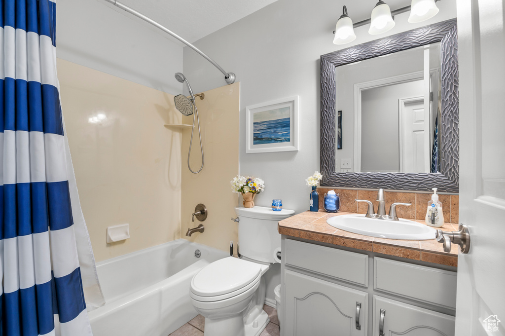 Bathroom with vanity, shower / tub combo with curtain, tile patterned flooring, and toilet