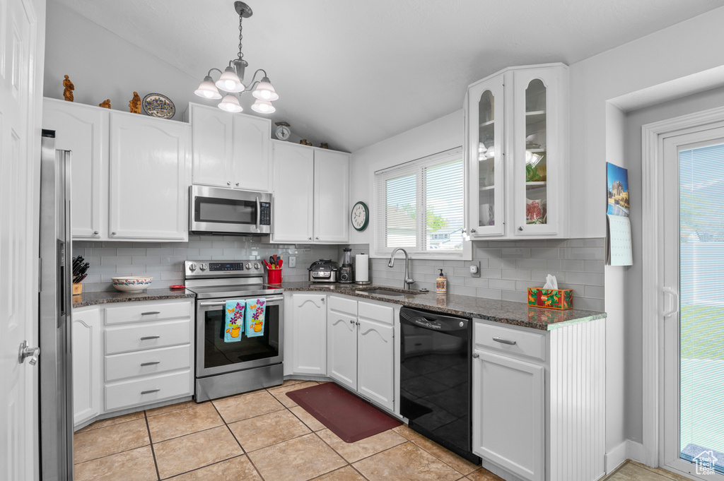 Kitchen featuring a sink, lofted ceiling, tasteful backsplash, and stainless steel appliances