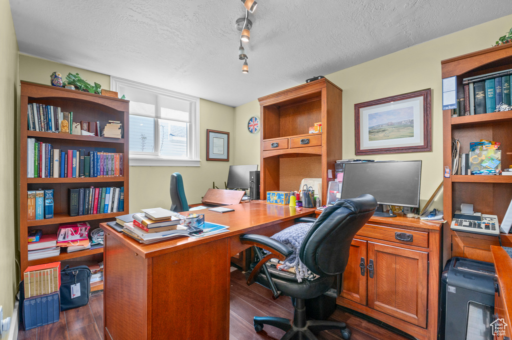 Office area featuring dark wood-style flooring and a textured ceiling