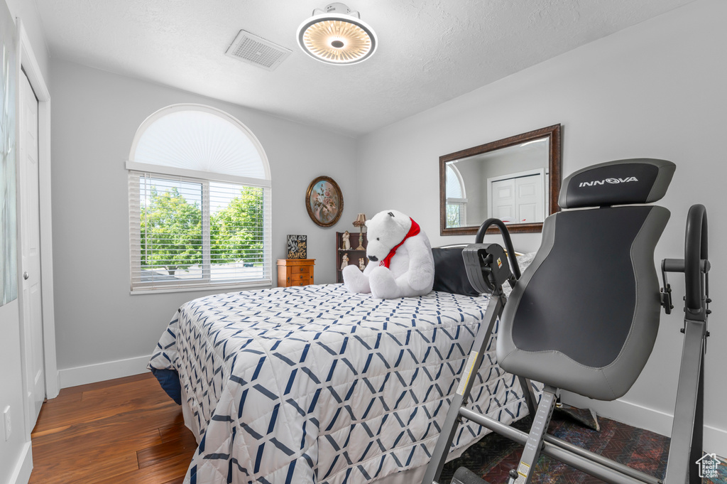 Bedroom with baseboards, wood finished floors, and visible vents