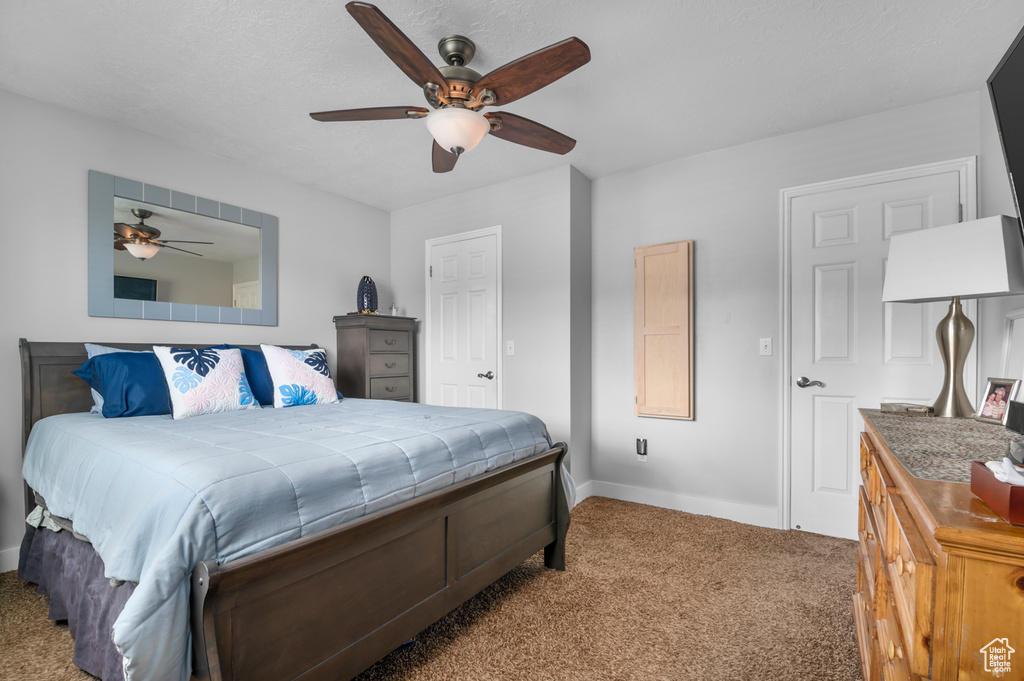 Carpeted bedroom with baseboards and ceiling fan