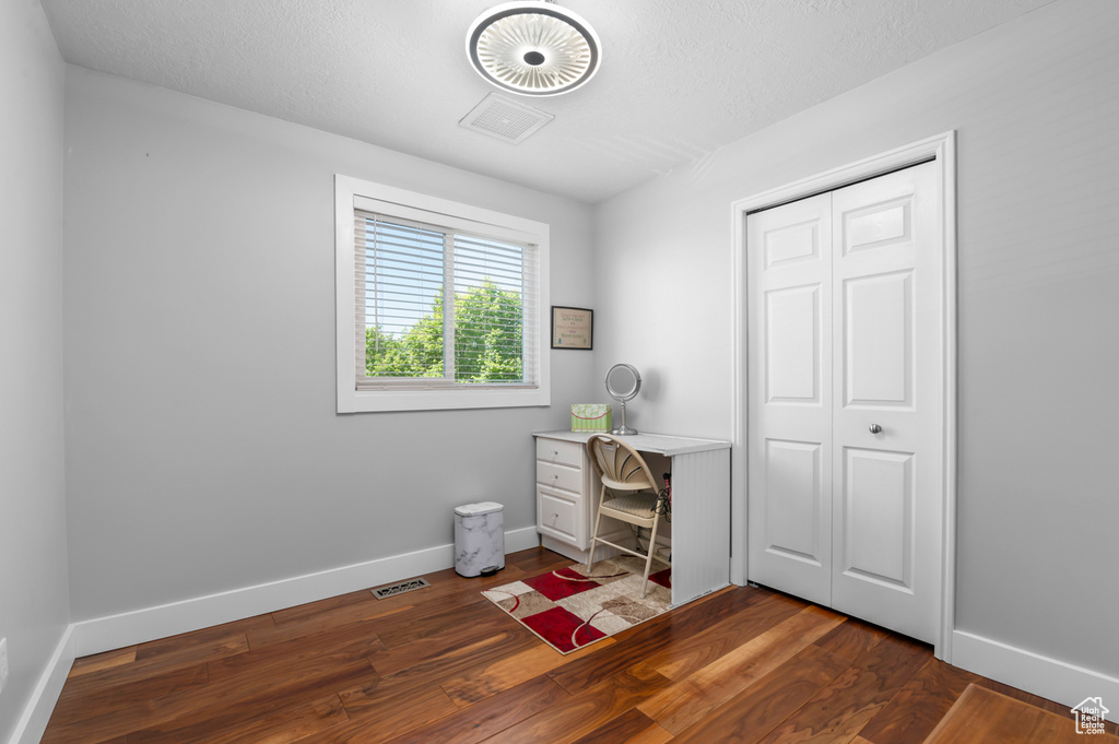 Interior space with baseboards, dark wood finished floors, and visible vents