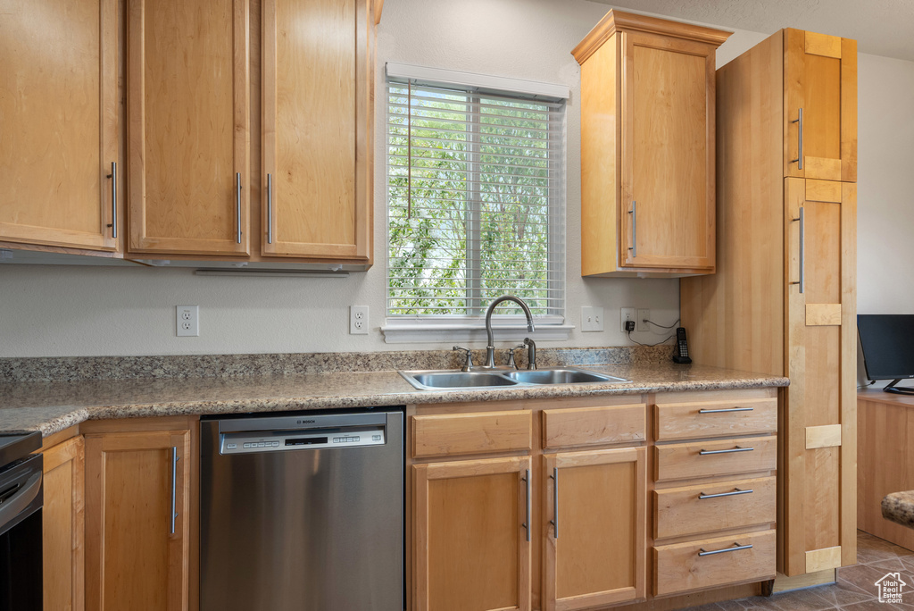 Kitchen featuring light countertops, plenty of natural light, stainless steel dishwasher, and a sink