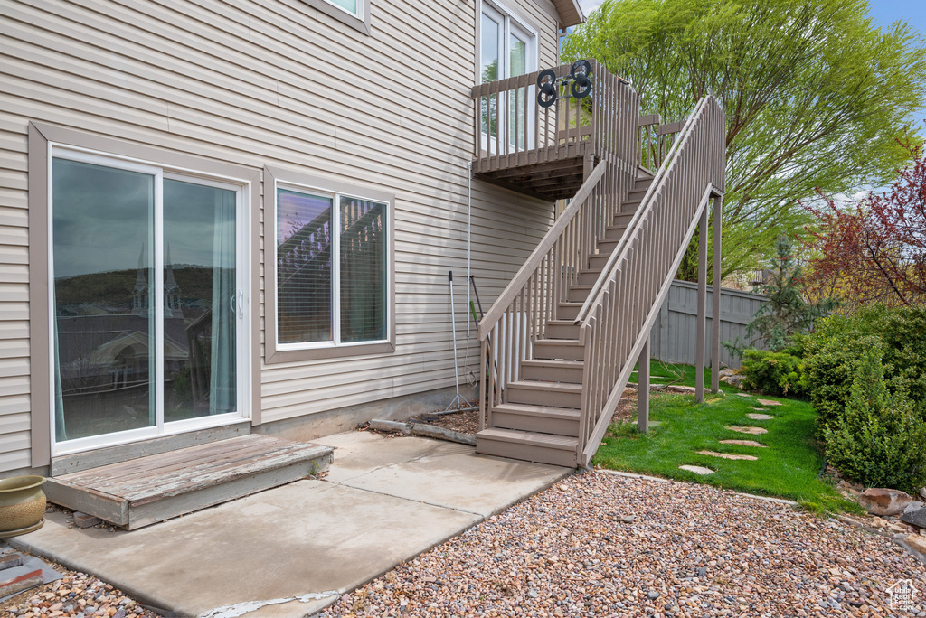 Property entrance with a patio area and a wooden deck
