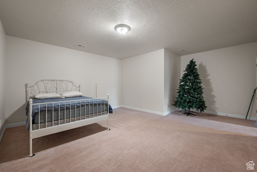 Bedroom with baseboards, a textured ceiling, and carpet flooring