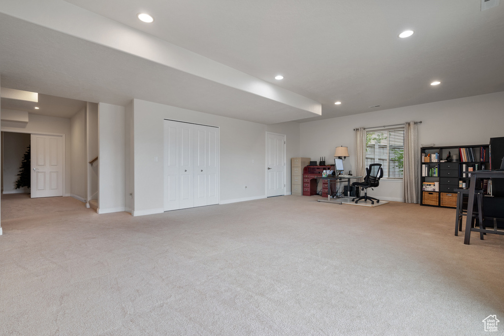 Interior space with baseboards, recessed lighting, and light carpet