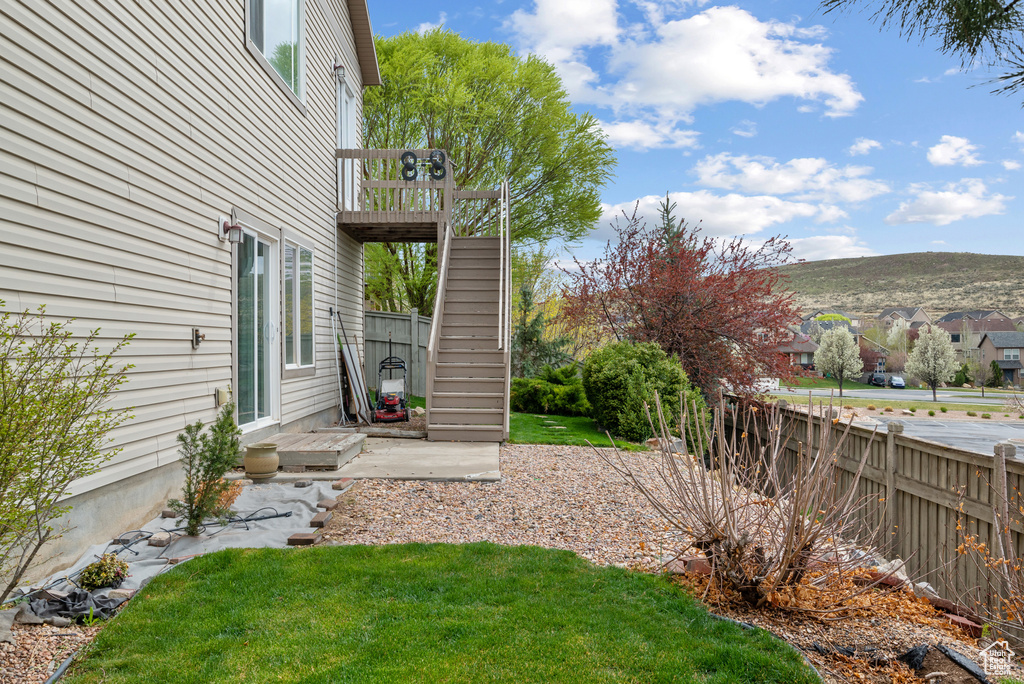 View of yard featuring fence, stairs, and a deck with mountain view